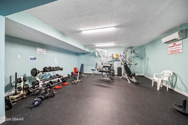 exercise room with a textured ceiling and a wall mounted air conditioner