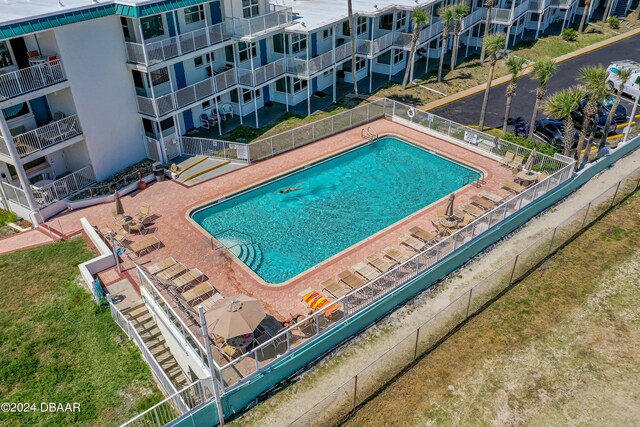 view of pool featuring a patio and a yard