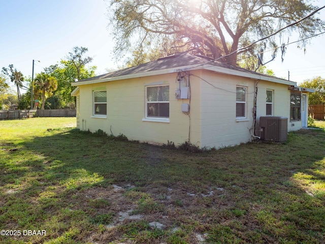 view of home's exterior featuring a yard, fence, and central AC