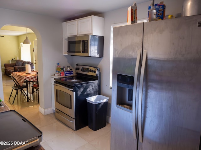 kitchen with white cabinetry, light tile patterned floors, arched walkways, and appliances with stainless steel finishes