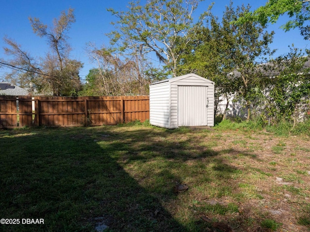 view of yard featuring an outbuilding, a storage unit, and a fenced backyard