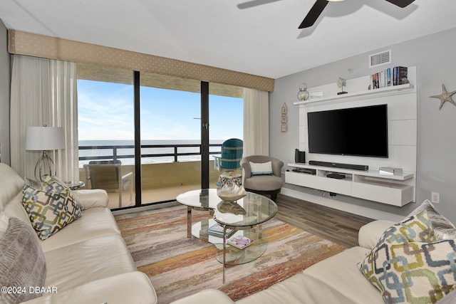 living room with a wealth of natural light, hardwood / wood-style flooring, and ceiling fan