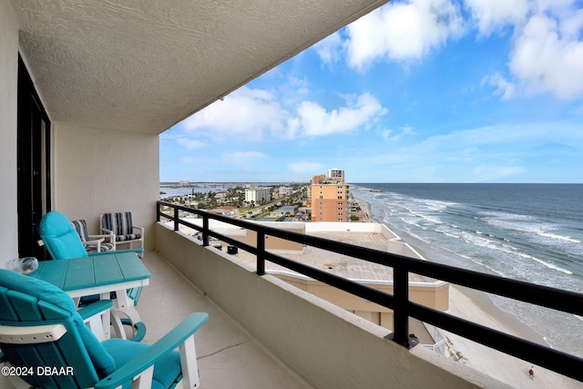 balcony with a water view and a beach view