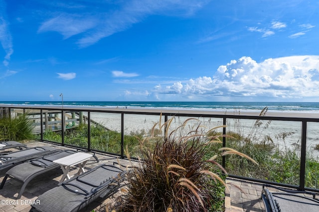 balcony featuring a view of the beach and a water view