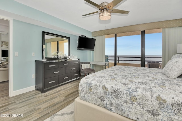 bedroom with multiple windows, light hardwood / wood-style flooring, and ceiling fan