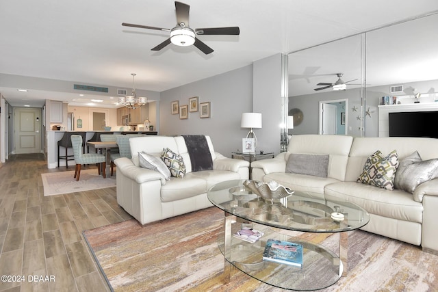 living room featuring hardwood / wood-style floors and ceiling fan with notable chandelier