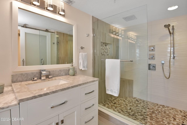 bathroom with vanity and a shower with door