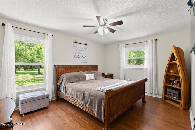 2455 Whooping Crane Dr, Deleon Springs, FL 32130 - bedroom featuring multiple windows, light wood-type flooring, ceiling fan, and a textured ceiling