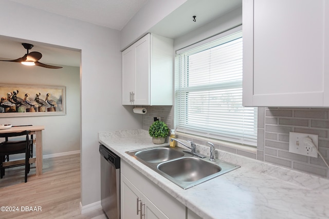 kitchen with decorative backsplash, sink, white cabinets, dishwasher, and light hardwood / wood-style flooring