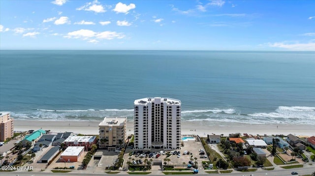 birds eye view of property with a water view and a beach view