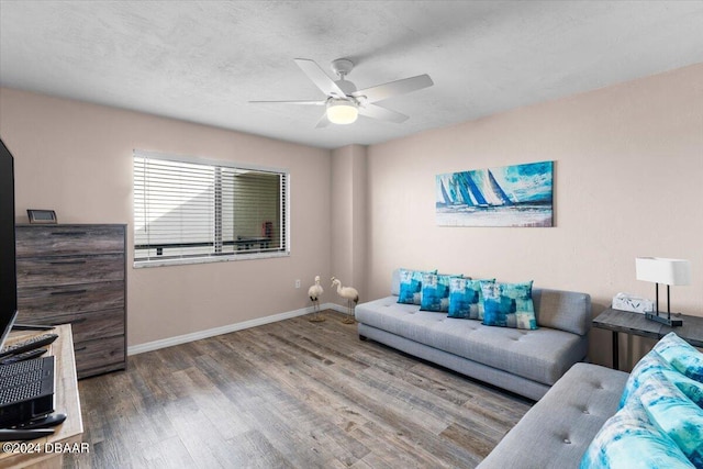 living room with hardwood / wood-style flooring, ceiling fan, and a textured ceiling