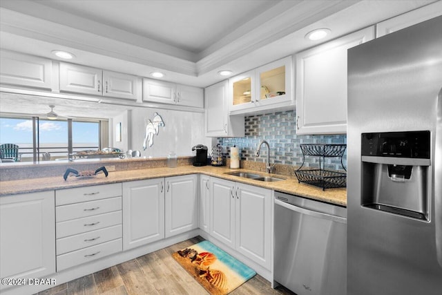 kitchen featuring white cabinets, light wood-type flooring, stainless steel appliances, and sink