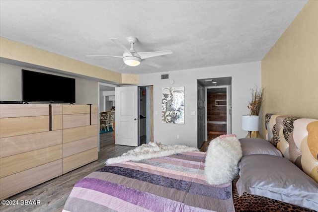 bedroom with ceiling fan, dark hardwood / wood-style floors, and ensuite bathroom