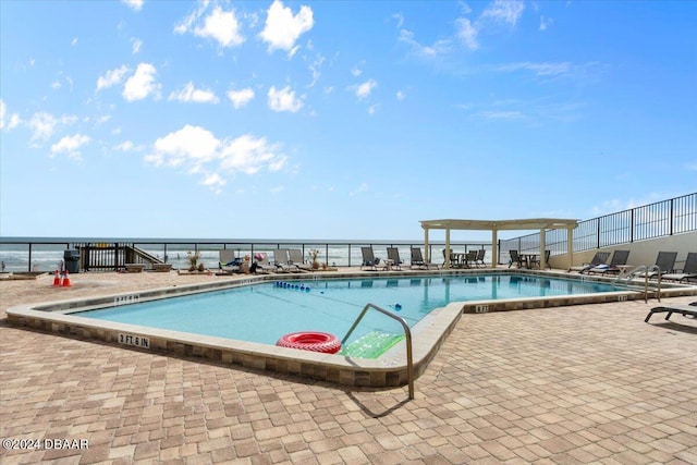 view of pool with a water view and a patio