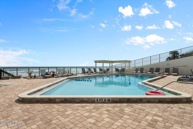 view of swimming pool with a water view and a patio area