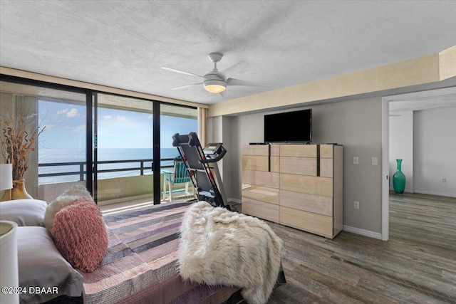 bedroom with access to exterior, a textured ceiling, hardwood / wood-style flooring, and ceiling fan