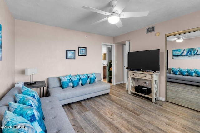 living room featuring hardwood / wood-style floors and ceiling fan