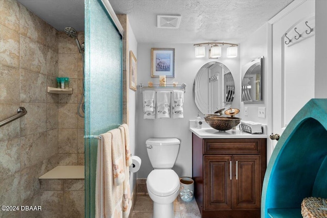 bathroom featuring walk in shower, a textured ceiling, vanity, tile patterned floors, and toilet