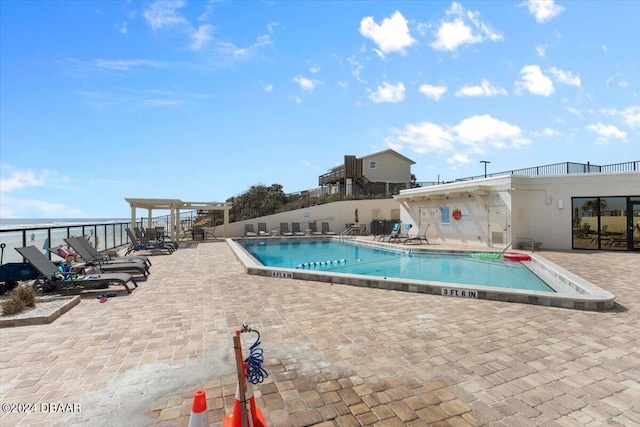 view of swimming pool with a water view and a patio area