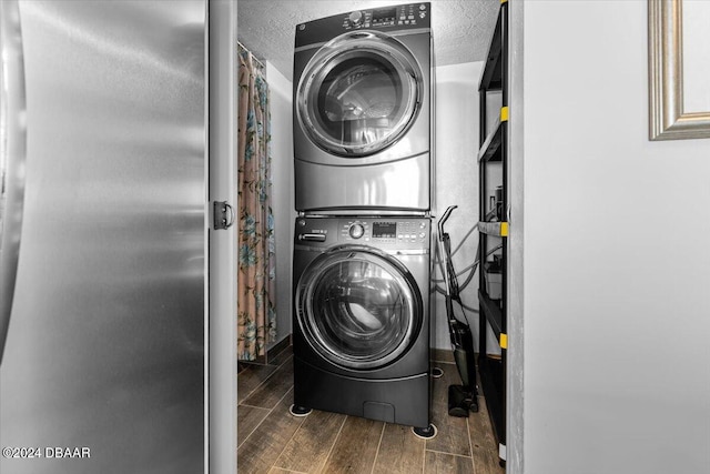 clothes washing area featuring stacked washer and clothes dryer and dark hardwood / wood-style floors