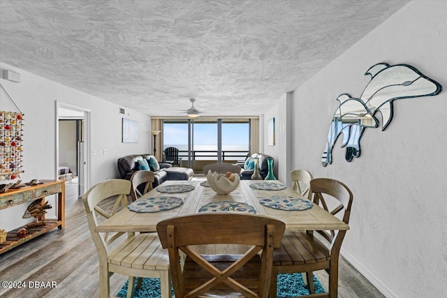 dining space featuring hardwood / wood-style floors, ceiling fan, and a textured ceiling