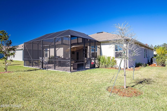 rear view of house with a lanai, a lawn, and a patio