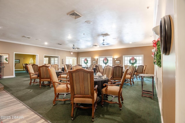 dining room featuring wood-type flooring, a wealth of natural light, and ornamental molding