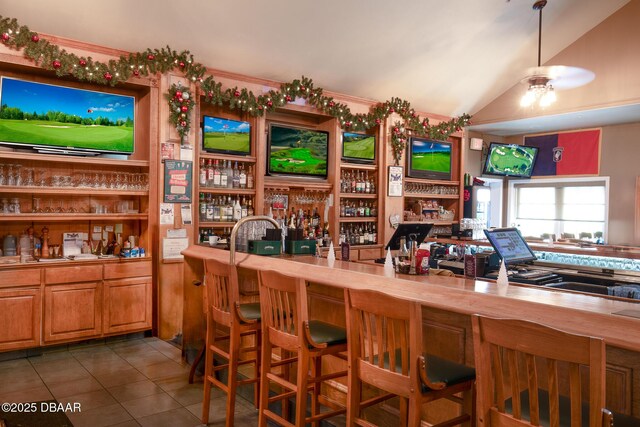 kitchen with wood counters, ceiling fan, dark tile patterned floors, and vaulted ceiling