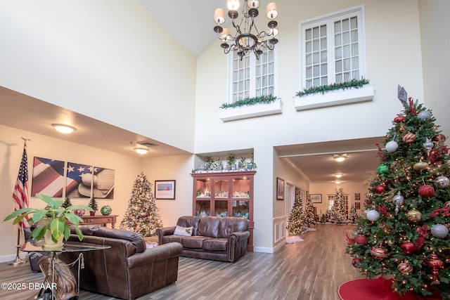 living room featuring high vaulted ceiling, a chandelier, and hardwood / wood-style flooring