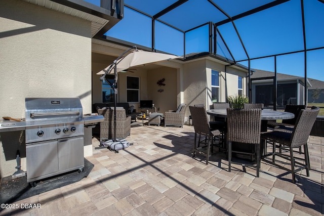 view of patio featuring glass enclosure and a grill