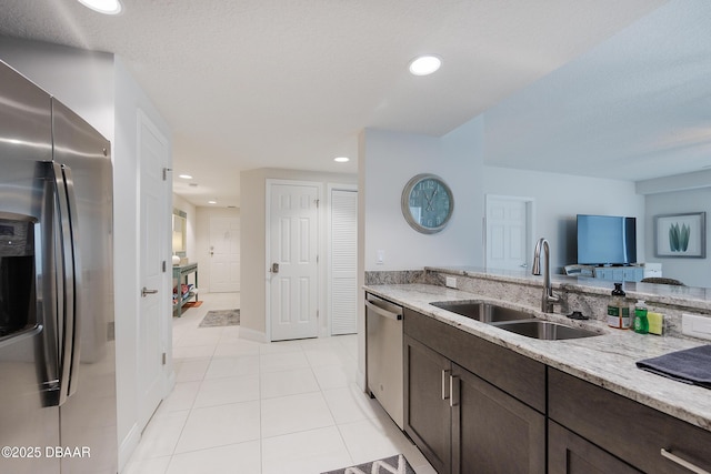 3721 S Atlantic Ave Unit 1101, Daytona Beach Shores, FL 32118 - kitchen with appliances with stainless steel finishes, dark brown cabinets, light tile patterned floors, light stone countertops, and recessed lighting