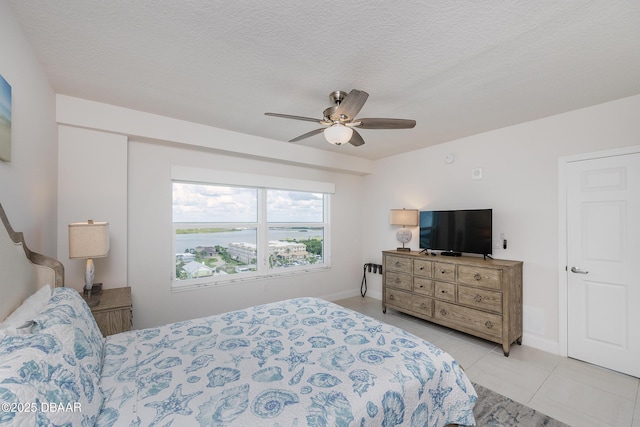 3721 S Atlantic Ave Unit 1101, Daytona Beach Shores, FL 32118 - bedroom featuring light tile patterned flooring, ceiling fan, and a textured ceiling