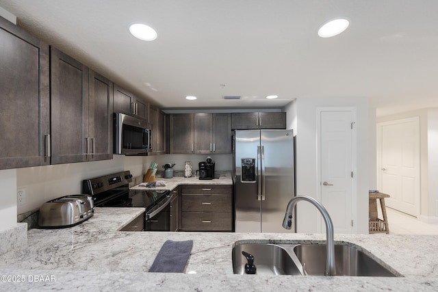 3721 S Atlantic Ave Unit 1101, Daytona Beach Shores, FL 32118 - kitchen featuring appliances with stainless steel finishes, dark brown cabinets, recessed lighting, and light stone countertops