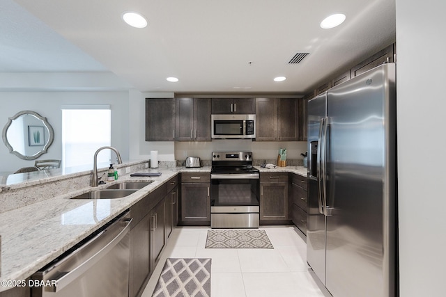 3721 S Atlantic Ave Unit 1101, Daytona Beach Shores, FL 32118 - kitchen with stainless steel appliances, dark brown cabinets, light stone countertops, light tile patterned floors, and recessed lighting