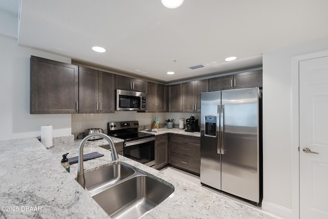 3721 S Atlantic Ave Unit 1101, Daytona Beach Shores, FL 32118 - kitchen with appliances with stainless steel finishes, dark brown cabinetry, light stone countertops, and recessed lighting