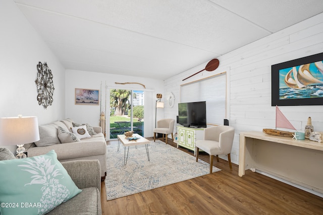 living room with hardwood / wood-style floors and wooden walls