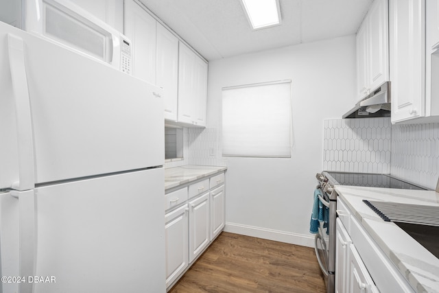 kitchen with decorative backsplash, white refrigerator, and white cabinetry