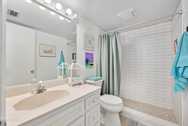 bathroom with toilet, a shower with curtain, vanity, and tile patterned floors