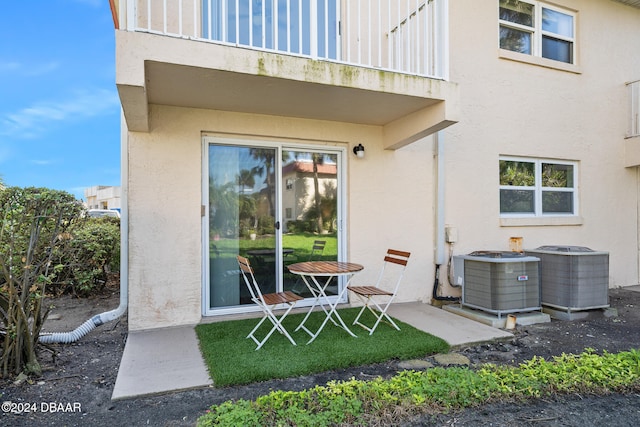 rear view of house featuring a balcony, cooling unit, and a patio