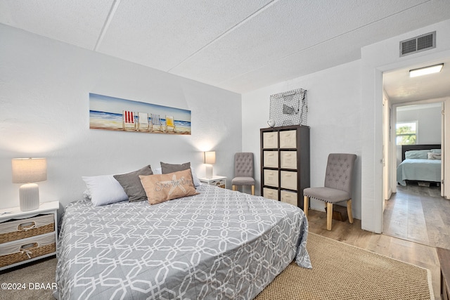 bedroom featuring hardwood / wood-style floors and a textured ceiling