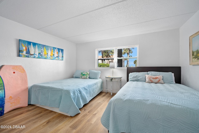 bedroom featuring wood-type flooring and a textured ceiling