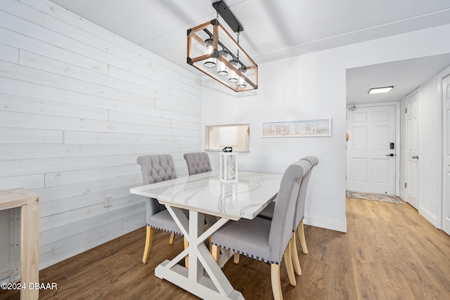 dining room featuring wood walls and light hardwood / wood-style floors