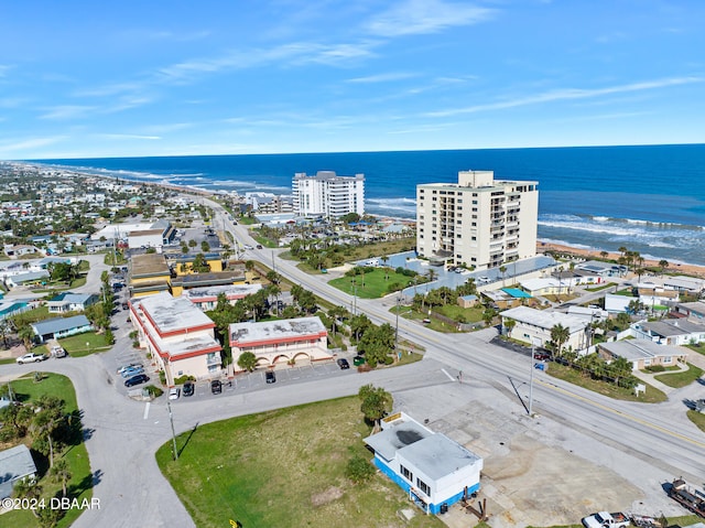 birds eye view of property with a water view and a beach view