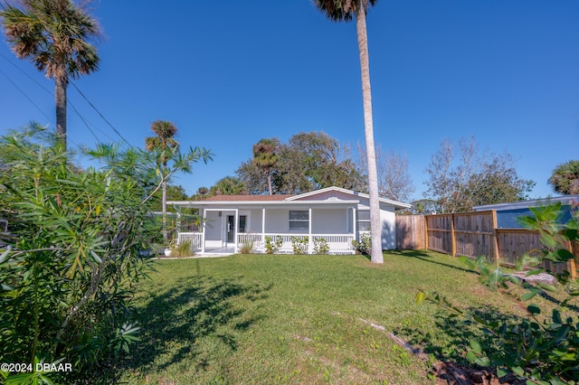 view of front of home with a sunroom and a front yard