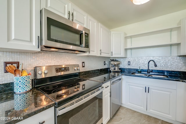 kitchen featuring backsplash, stainless steel appliances, white cabinetry, and sink