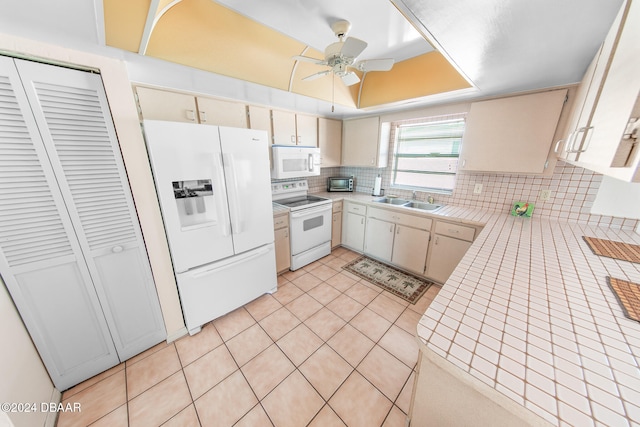 kitchen featuring tasteful backsplash, white appliances, ceiling fan, sink, and tile counters