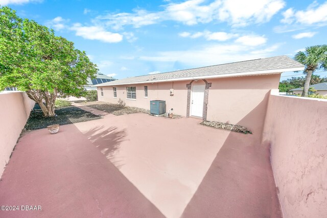 110 Ponce Terrace Cir, Ponce Inlet, FL 32127 - back of house featuring central AC, stucco siding, a patio, and fence