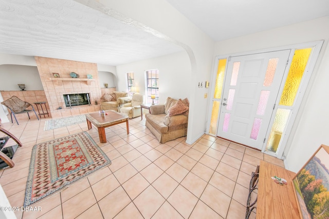 110 Ponce Terrace Cir, Ponce Inlet, FL 32127 - living area featuring arched walkways, light tile patterned floors, a tile fireplace, and a textured ceiling