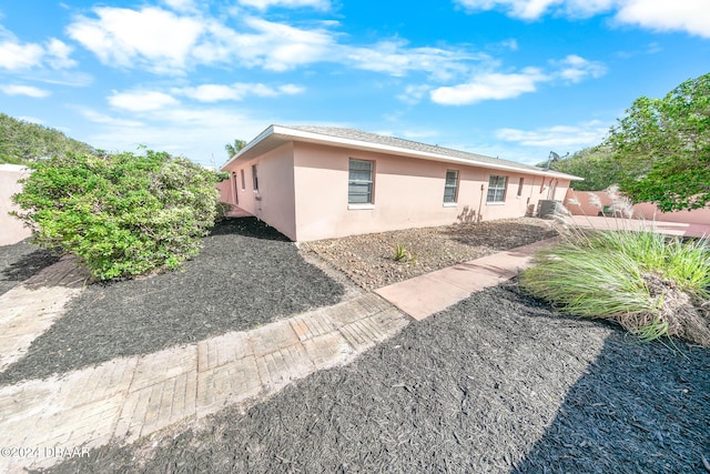 110 Ponce Terrace Cir, Ponce Inlet, FL 32127 - back of house featuring stucco siding and cooling unit