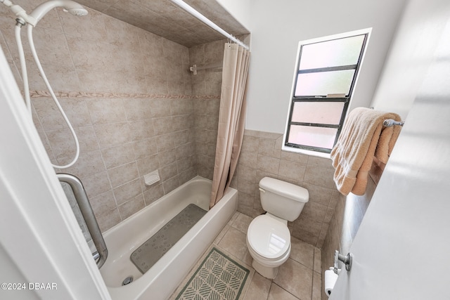 bathroom with tile patterned floors, toilet, shower / bath combo with shower curtain, and tile walls